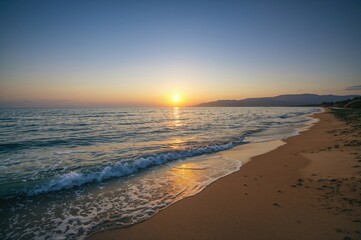 Sunset disappearing beyond the distant waves