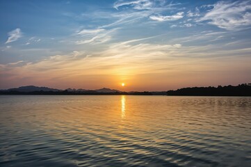 Fototapeta premium Sunset's golden glow mirrored on a tranquil reservoir lake