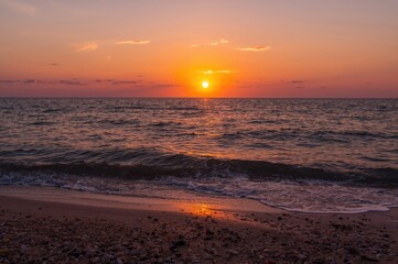 Fototapeta premium Sun setting beyond the sea horizon