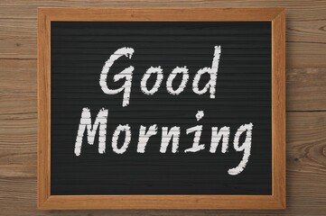 Morning greetings displayed on a blackboard with a wooden backdrop