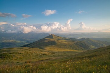 Fototapeta premium A scenic view of hills, clouds, and meadows during a warm mountain season