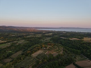 Sunset over fields and forest near Lake Bolsena, Italy
Drone image showing rolling hills, farmland and forest leading to Lake Bolsena at sunset, with the full moon visible.