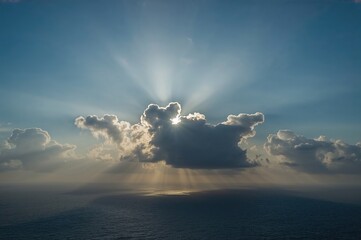 Sun rays breaking through clouds over the sea