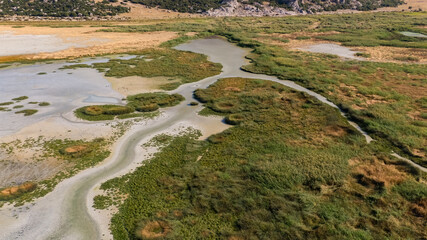 Fototapeta premium Wetlands and environmental transition. Visual representation highlighting ecological diversity through waterways, reed beds, and arid land. Yarışlı Lake, Burdur, Turkey.
