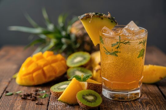 Delicious tropical beverage featuring mango and assorted fresh fruits on a wooden surface - Powered by Adobe