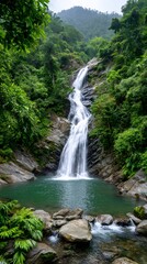 Waterfall cascading into turquoise pond in lush green rainforest