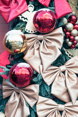 Elegant Christmas tree decorated with handcrafted satin bows, shiny red and gold balls, and wooden angel ornaments, creating a festive market-style atmosphere