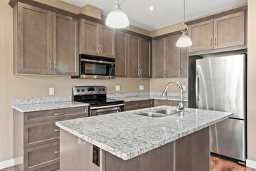 Kitchen with a stainless steel refrigerator, sink, and microwave