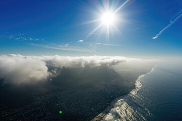 Sunlight floods the urban skyline viewed from a helicopter overhead.