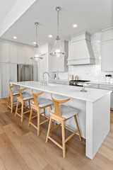 Kitchen with a white counter and wooden chairs