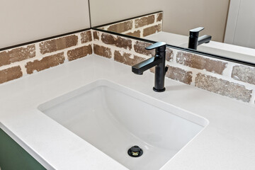 Sink with a black faucet and a white countertop