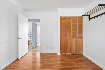 Small bedroom with a white door and a wooden closet