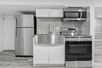 Stainless steel sink is in front of a refrigerator