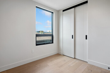 Small, empty room with a window and a white closet