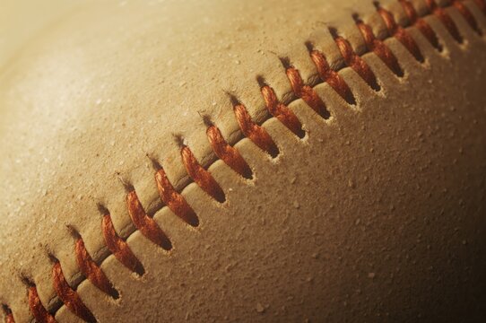 Detailed view of the seams on an aged softball surface, featuring a pattern and texture with a sporty, vintage vibe