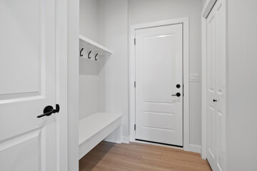 White door with a black handle and a white bench in front of it