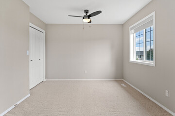 White room with a black fan and a window