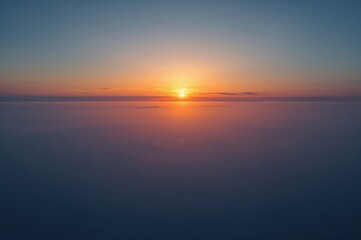 Obraz premium A captivating shot showcasing the peaceful beauty of dawn, illuminating a vast landscape with soft, warm hues. The skyline is adorned with a mix of amber and azure shades.