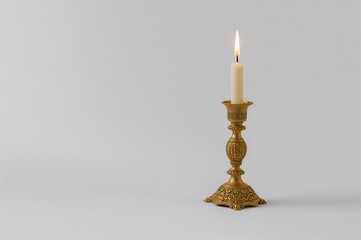 Antique candle aflame in a gilded holder against a white backdrop