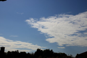 Blue sky with fluffy white clouds
Bright blue sky with soft white clouds, natural background for design and illustration.