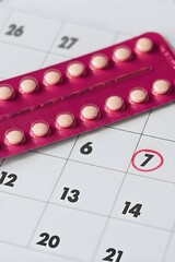 Pink blister pack with oral contraceptive pills on calendar background, vertical poster for contraception month women’s health family planning and reproductive medicine awareness with copyspace.