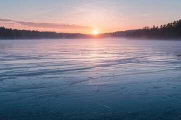 Sunrise over a frozen lake with ice fishing activities