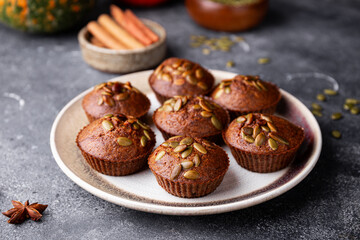 Autumn pumpkin cupcakes or baked muffins with fresh pumpkin and pumpkin seeds for Thanksgiving day