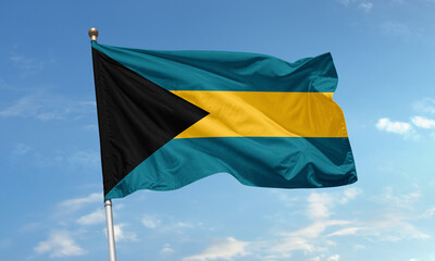 Bahamas national flag with aquamarine stripes and black triangle fluttering in the tropical coastal breeze under clear skies