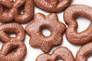 Chocolate covered gingerbread cookies in different shapes on white background. Sweet traditional dessert with cocoa glaze. Delicious festive snack for holiday or daily sweet treat lovers.