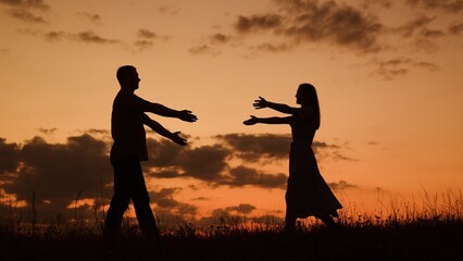Couple in love meets in nature. Silhouettes of man woman walking toward each other, loving couple embracing at sunset, slow motion. Love story happy family. Romantic date love of happy couple in park