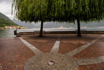 Peaceful Lakeside Platform with Benches and Trees Overlooking Soothing Lake Como Scenery