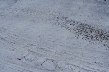 Snowy Ground with Tire Tracks and Mud Marks