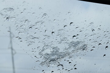 Melting Ice and Raindrops on Car Window