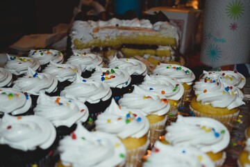 Chocolate and Vanilla Cupcakes with White Icing on Table