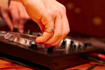 hand of dj mixing music on dj mixer