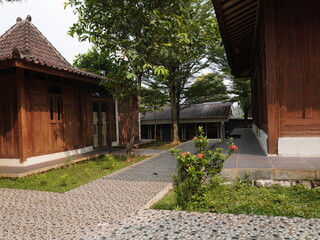 Serene traditional wooden buildings nestled amidst lush green gardens and natural stone pathways
