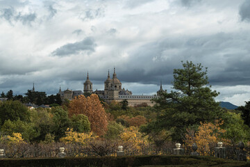 Obraz premium views of the Monastery of El Escorial and its historic gardens surrounded by autumn trees and spectacular skies.