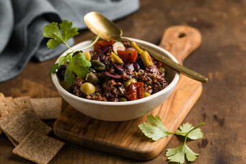 Olive tapenade with herbs and olive oil in a rustic bowl