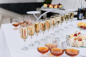 Glasses of champagne and fruit snacks on wedding reception table outdoors