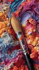 Vibrant pigments and a paintbrush rest on a colorful palette, showcasing a rich array of hues.