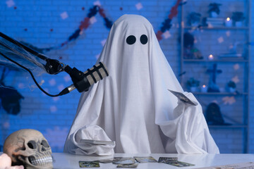 Ghost costume recording podcast or blog in a studio with blue light