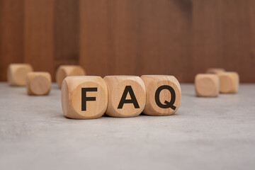 wooden cubes with the word FAQ on a table