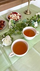 Sommerliches Buffet mit Blätterteigrosen, Vanilleeis und Obstdeko auf grün gedecktem Tisch goldene Tischdeko Anlass Hochzeitdeko Partybuffet