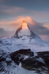 Snow-covered Matterhorn peak glowing at sunrise with dramatic sky, winter alpine landscape