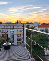 Sonnenuntergang über den Dächern Berlins vom Balkon aus orange gelber Himmel über der Stadt...