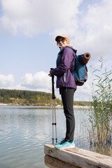 Female traveler standing on log by lake