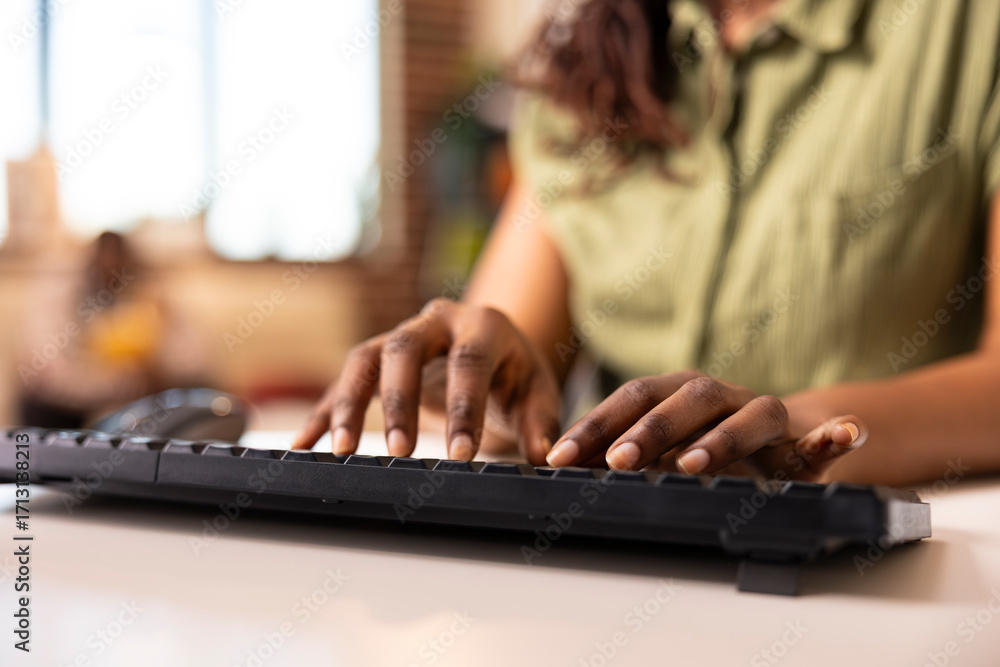 Poster close up of black female individual typing data on keyboard while working remotely. african american