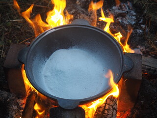 fire in a fireplace The first firing of the cauldron over an open fire with table salt