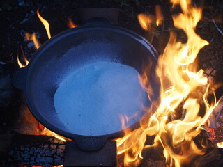 fire in a fireplace The first firing of the cauldron over an open fire with table salt