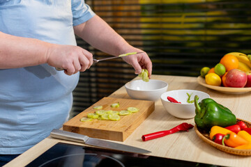 A Person Engaged in Preparing Fresh and Colorful Vegetables Within a Modern Kitchen Setting